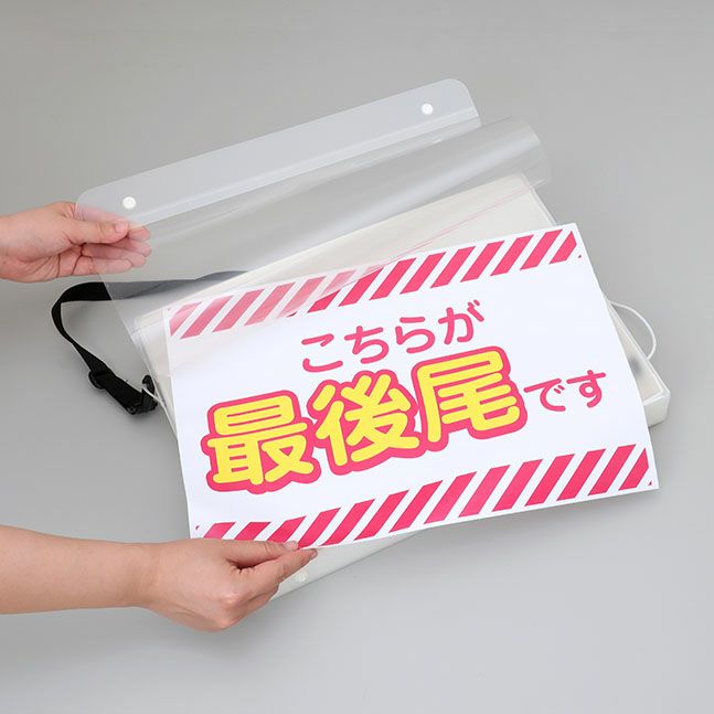 光る手持ち看板の印刷物（イメージ）を差し替えている様子の画像