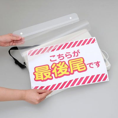 光る手持ち看板の印刷物（イメージ）を差し替えている様子の画像