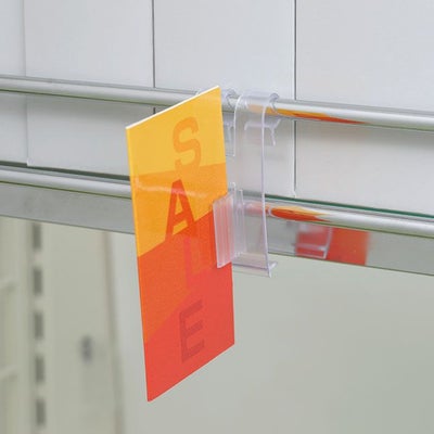 ＳＧワイヤーサインホルダーの使用例写真、シェルフ棚のワイヤーに本体をひっかけクリップ部分に印刷物が掲示されている画像